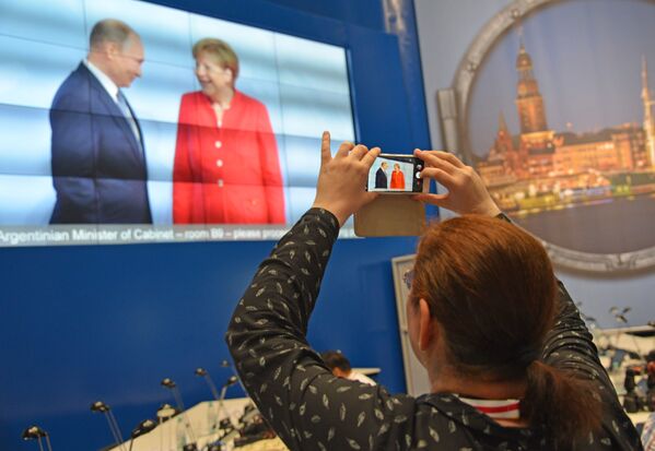 Журналисты в международном пресс-центре во время трансляции официальной встречи президента РФ Владимира Путина канцлером Германии Ангелой Меркель на открытии саммита государств-участников Группы двадцати G20 в Гамибурге - Sputnik Молдова