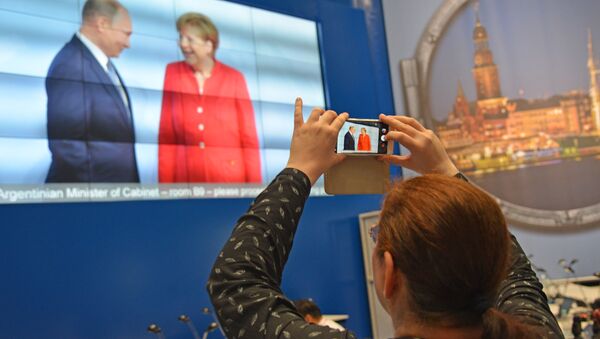 Журналисты в международном пресс-центре во время трансляции официальной встречи президента РФ Владимира Путина канцлером Германии Ангелой Меркель на открытии саммита государств-участников Группы двадцати G20 в Гамибурге - Sputnik Молдова