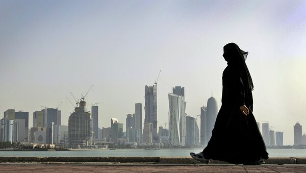 A Qatari woman walks in front of the city skyline in Doha, Qatar.  - Sputnik Moldova-România