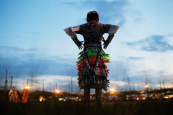 Девятилетняя Анхинга Бенални, спортсменка-юниорка из Навахо, готовится танцевать в первую ночь 32-го ежегодного Таос-Пуэбло-Пау-Вау, конкурса танцев коренных американцев, в Нью-Мексико, США - Sputnik Молдова