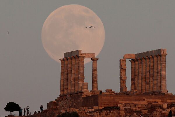 Полная луна поднимается над Храмом Посейдона, древнегреческого бога морей, в Мысе Сунион, к востоку от Афин, Греция - Sputnik Молдова