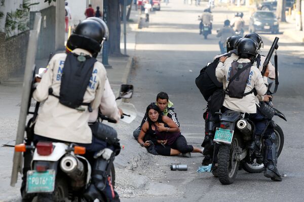 Пострадавшие от слезоточивого газа протестующие спасаются от сил безопасности во время митинга против правительства президента Венесуэлы Николаса Мадуро в Каракасе - Sputnik Молдова