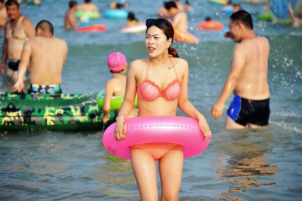 Девушка во время отдыха на пляже Циндао в Китае - Sputnik Молдова