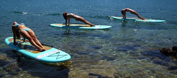 Девушки занимаются йогой на воде на побережье Адриатического моря в Хорватии - Sputnik Молдова