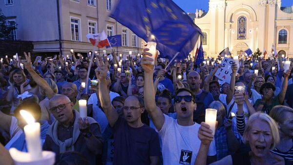 Anti-government protesters raise candles and shout slogans, as they gather in front of the Supreme Court in Warsaw, Poland, Saturday, July 22, 2017 - Sputnik Moldova-România