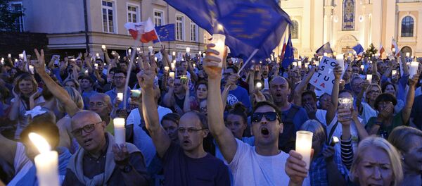 Anti-government protesters raise candles and shout slogans, as they gather in front of the Supreme Court in Warsaw, Poland, Saturday, July 22, 2017 - Sputnik Moldova-România