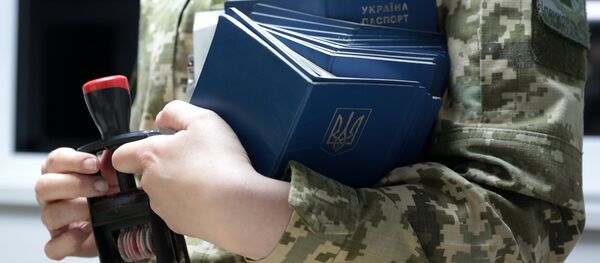 O angajată a serviciului vamal ucrainean verifică pașapoartele concetățenilor săi la trecerea frontierei - Sputnik Moldova