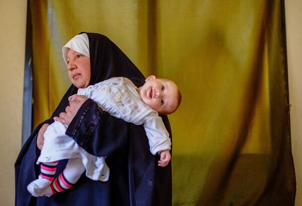 Женщина с ребенком - беженцы из Сирии - в одном из домов в городе Хальба на севере Ливана, 2013 год - Sputnik Молдова