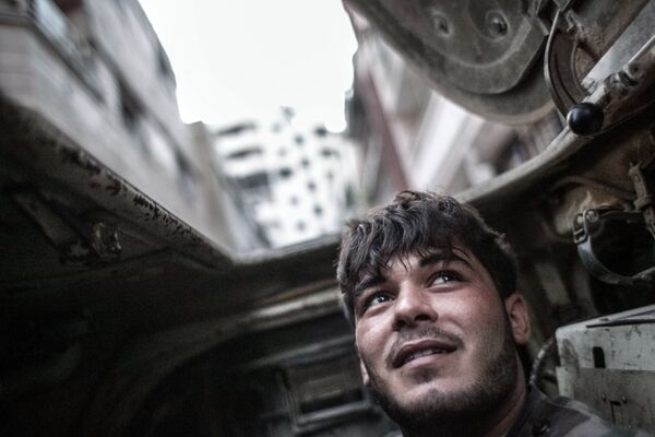 Военнослужащий правительственных войск внутри бронетранспортера во время столкновений с боевиками в центре Хомса, 2013 год - Sputnik Молдова