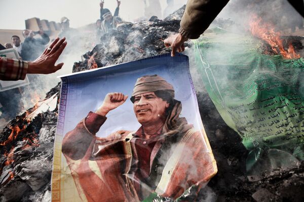 Жители Бенгази сжигают портреты Муамара Каддафи, плакаты с его цитатами и Зеленую книгу Каддафи, 2011 год - Sputnik Молдова