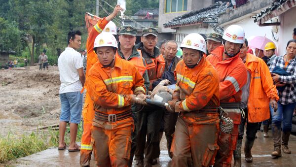 Rescue workers carry an injured villager at the site of a landslide that occurred in Gengdi village, Puge county, Sichuan province, China August 8, 2017 - Sputnik Moldova-România