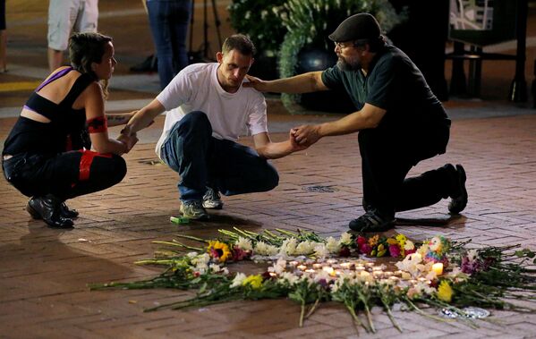 Люди пытаются успокоить Джозефа Калвера (в центре), когда он встает на колени, чтобы выразить свое уважение другу, пострадавшему в результате наезда автомобиля - Sputnik Молдова