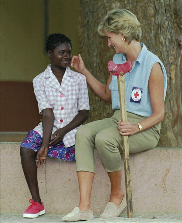 Принцесса Диана разговаривает с девочкой во время поездки в город Сауримо, Ангола, 1994 год - Sputnik Молдова