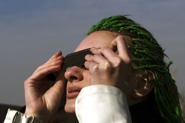 Девушка наблюдает солнечное затмение Девушка наблюдает солнечное затмение - Sputnik Молдова