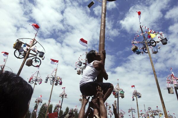 Мужчина пытается забраться на столб, чтобы выиграть велосипед во время празднования Дня независимости на Бали, Индонезия - Sputnik Молдова