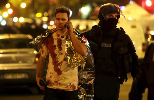 French policeman assists a blood-covered victim near the Bataclan concert hall following attacks in Paris, France, November 14, 2015 French policeman assists a blood-covered victim near the Bataclan concert hall following attacks in Paris, France, November 14, 2015 - Sputnik Moldova-România