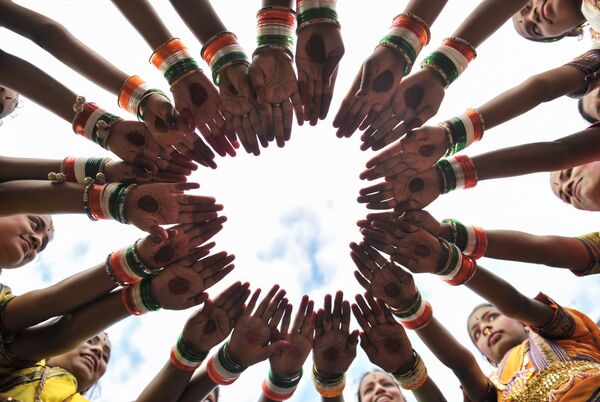 Индийские девушки надевают трёхцветные браслеты перед тем, как принять участие во время празднования Дня независимости - Sputnik Молдова