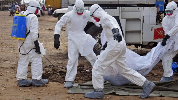 Health workers carry the body of a man suspected of dying from the Ebola virus and left in the street - Sputnik Moldova-România