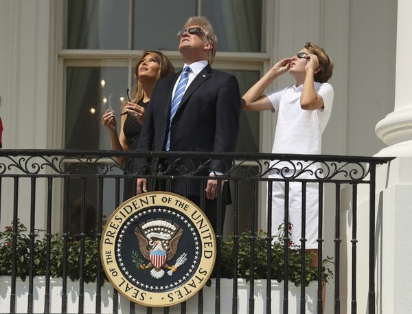 Президент Дональд Трамп, первая леди Мелания Трамп и их сын Бэррон наблюдают за солнечным затмением в Белом доме в Вашингтоне - Sputnik Молдова