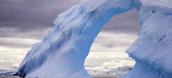 Снимок Ледяные ворота фотографа Гуды Чалун. На кадре - айсберг, плывущий в море у берегов Антарктиды. Эта арка сформировалась из-за воздействия ветра и температурных изменений, разрушивших лед. - Sputnik Moldova