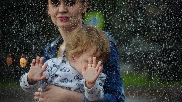 Mamiă cu copilul în brațe pe timp de ploaie - Sputnik Moldova-România