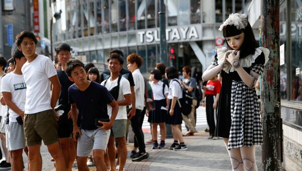 Прохожие смотрят на «кукольную» модель Лулу Хашимото, стоящую на улице во время фотовыставки в Токио, Япония - Sputnik Moldova-România