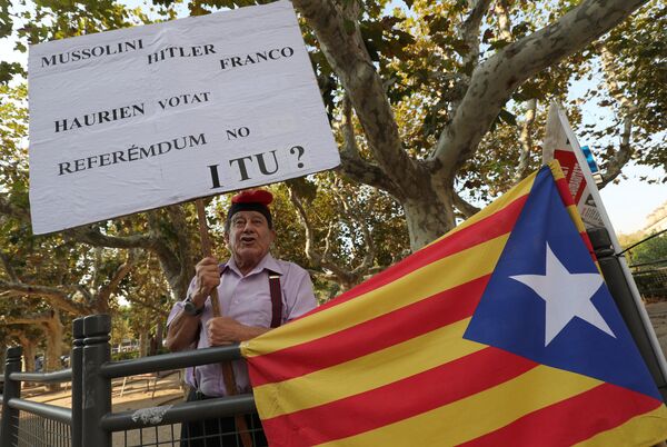 Сторонник независимости Каталонии стоит с плакатом у здания регионального парламента Каталонии в Барселоне Сторонник независимости Каталонии стоит с плакатом у здания регионального парламента Каталонии в Барселоне - Sputnik Молдова