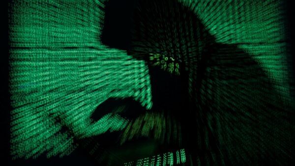 A hooded man holds a laptop computer as cyber code is projected on him in this illustration picture taken on May 13, 2017 - Sputnik Moldova-România