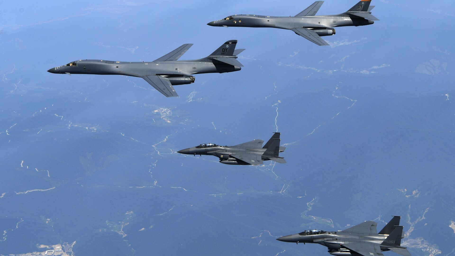 In this June 20, 2017 file photo provided by South Korean Defense Ministry, U.S. Air Force B-1B bombers, top, and second from top, and South Korean fighter jets F-15K fly over the Korean Peninsula, South Korea - Sputnik Moldova-România, 1920, 26.02.2021