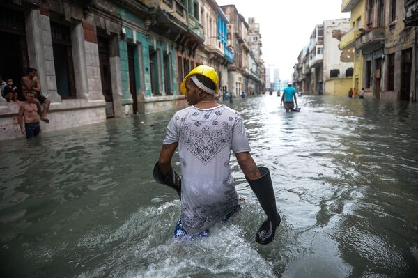 Кубинцы идут по затопленной улице в Гаване после урагана Ирма, обрушившегося на остров - Sputnik Молдова