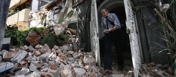Человек в дверном проеме здания, разрушенного в результате землетрясения в Мехико Человек в дверном проеме здания, разрушенного в результате землетрясения в Мехико - Sputnik Молдова