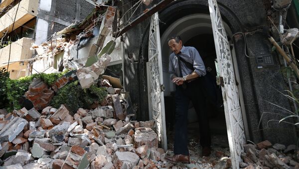 Человек в дверном проеме здания, разрушенного в результате землетрясения в Мехико - Sputnik Молдова