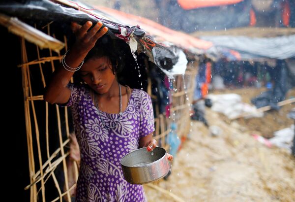 Девочка из беженцев-рохинджа собирает дождевую воду во временном лагере в городе Кокс-Базар, Бангладеш - Sputnik Молдова