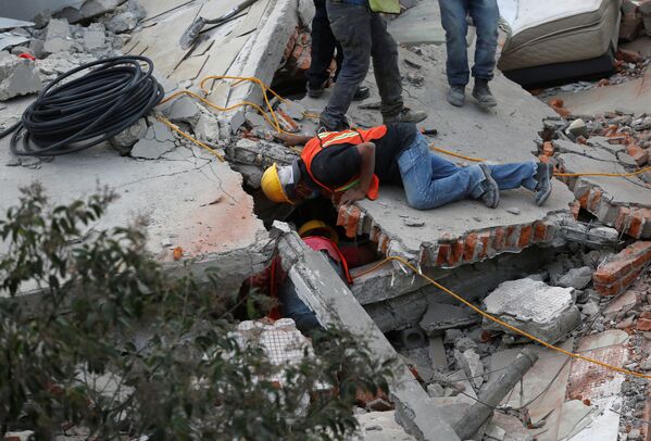 Rescue personnel search for people among the rubble of a collapsed building after an earthquake hit Mexico City, Mexico September 19, 2017 - Sputnik Молдова