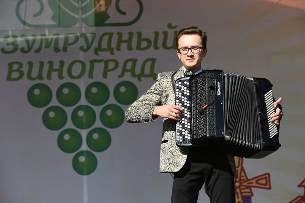 Un participant la Festivalul moldovenesc „Strugurele de smarald” interpretează melodii la acordeon - Sputnik Moldova