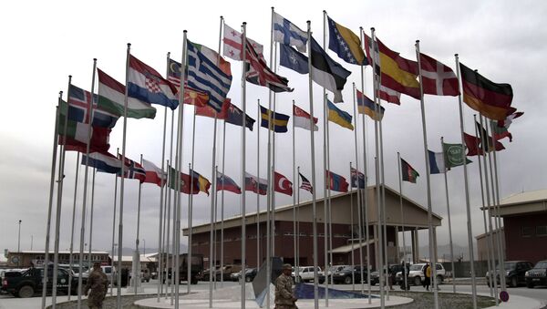 NATO Soldiers walk under country member flags at a NATO base at Kabul International Airport in Kabul, Afghanistan - Sputnik Moldova-România