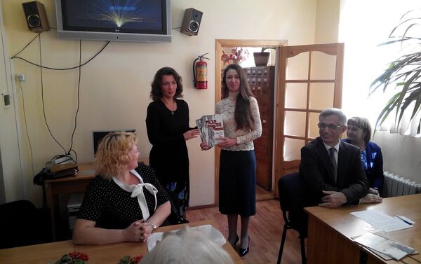 Литератор Наталья Новохатняя вручает гостям из России номера журнала Русское поле - Sputnik Молдова