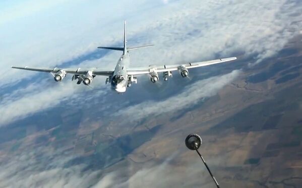 Дозаправка в воздухе стратегического бомбардировщика-ракетоносца Ту-95МС во время выполнения боевой задачи по нанесению ударов крылатыми ракетами Х-101 по объектам террористов в Сирии - Sputnik Молдова