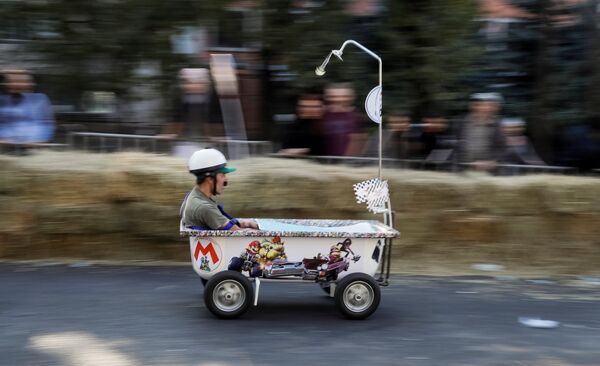 Спортсмен управляет своим самодельным транспортным средством без двигателя во время гонки Soapbox Red Bull в Алматы, Казахстан - Sputnik Молдова