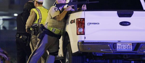 A police officer takes cover behind a truck at the scene of a shooting near the Mandalay Bay resort and casino on the Las Vegas Strip, Sunday, Oct. 1, 2017, in Las Vegas - Sputnik Moldova-România