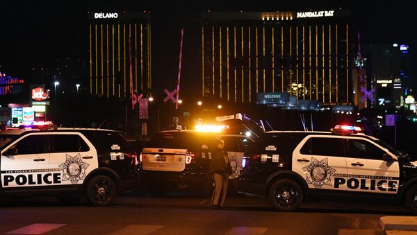Police form a perimeter around the road leading to the Mandalay Hotel (background) after a gunman killed at least 50 people and wounded more than 200 others when he opened fire on a country music concert in Las Vegas, Nevada - Sputnik Moldova-România