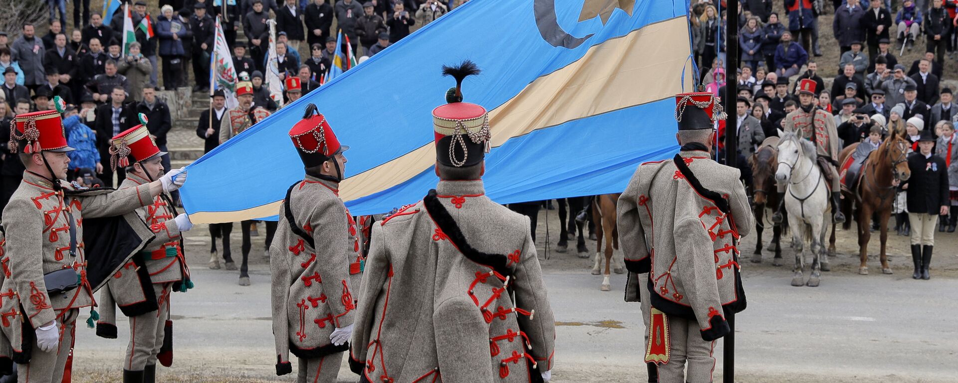 Etnicii maghiari purtând uniforme de epocă ridică steagul secuiesc - Sputnik Moldova-România, 1920, 23.02.2022