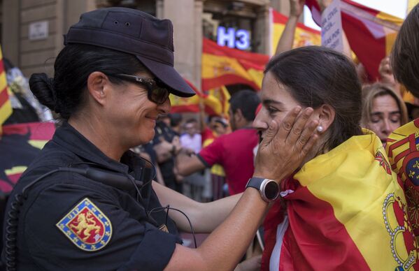Полицейский разговаривает с участником митинга в защиту единства Испании в Барселоне - Sputnik Молдова