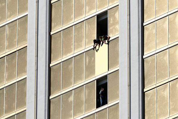Рабочие заколачивают разбитое окно в отеле Mandalay Bay в Лас-Вегасе. - Sputnik Молдова