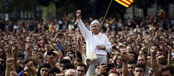People raise their fists during a protest in Barcelona on October 2, 2017 a day after hundreds were injured in a police crackdown during Catalonia's banned independence referendum. - Sputnik Moldova-România