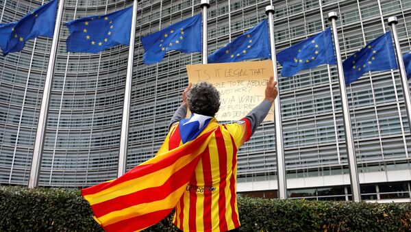 Catalan Raimon Castellvi wears a flag with an Estelada (Catalan separatist flag) as he protests outside the European Commission in Brussels after Sunday's independence referendum in Catalonia, Belgium, October 2, 2017. - Sputnik Moldova-România