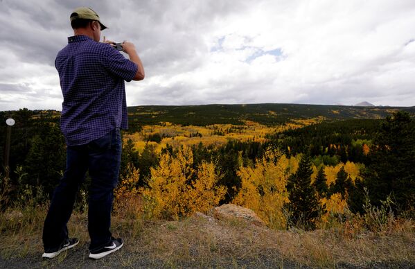 Мужчина фотографирует осенний лес в Аспене, Колорадо - Sputnik Молдова