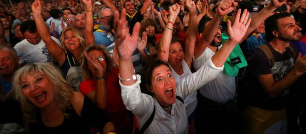 Люди смотрят трансляцию заседания Каталонского регионального парламента во время митинга за независимость в Барселоне - Sputnik Молдова