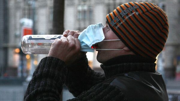 Житель Киева в защитной маске пьет водку. - Sputnik Молдова