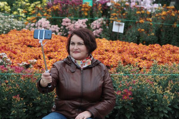 Посетительница фотографируется на открытии выставки Бал хризантем в Никитском ботаническом саду - Sputnik Молдова